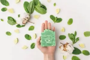 cropped shot of woman holding handcrafted soap on white surface